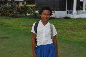 A friendly and curious school girl stops to get her photo taken.